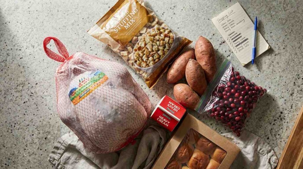 Grocery-store Thanksgiving ingredients on a kitchen counter with a blank shopping list